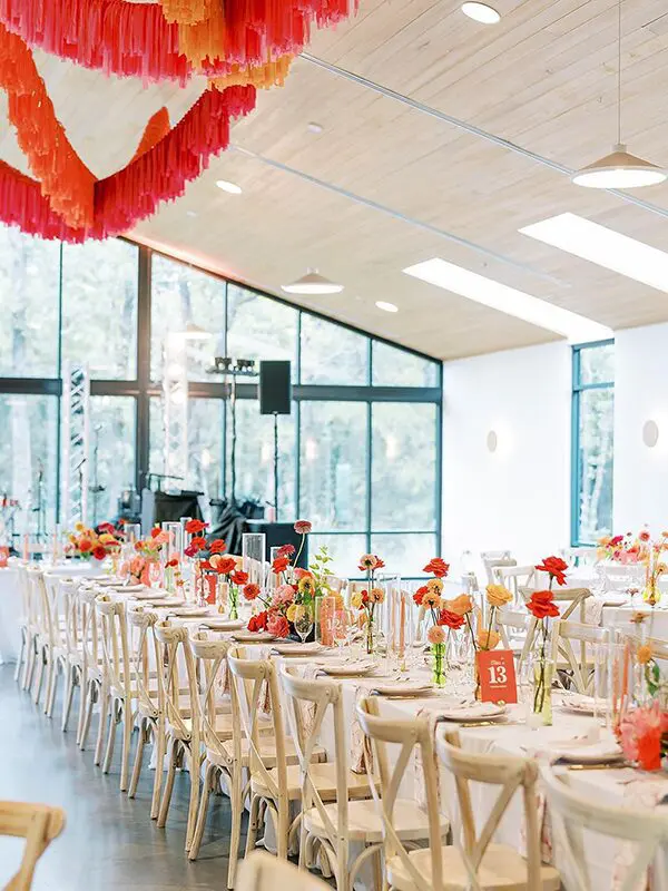 A long table with many chairs and flowers on it