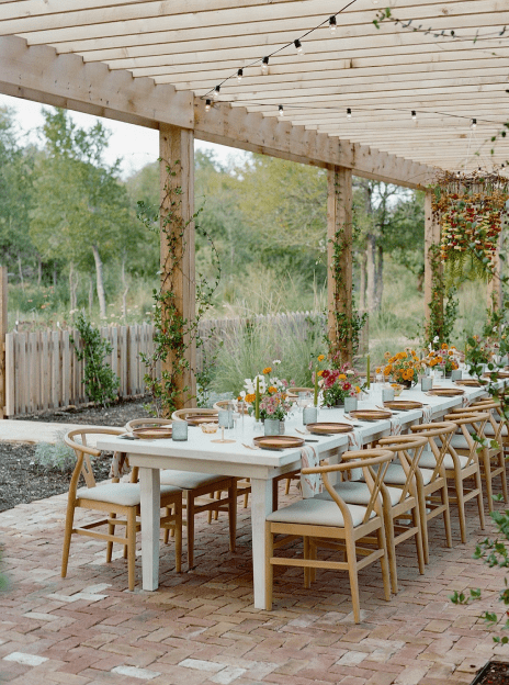 A table with many chairs and flowers on it