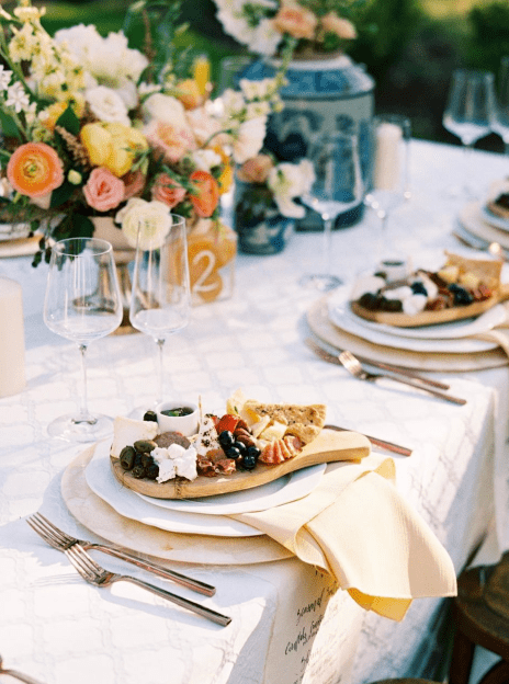 A table set with plates and silverware, glasses and flowers.