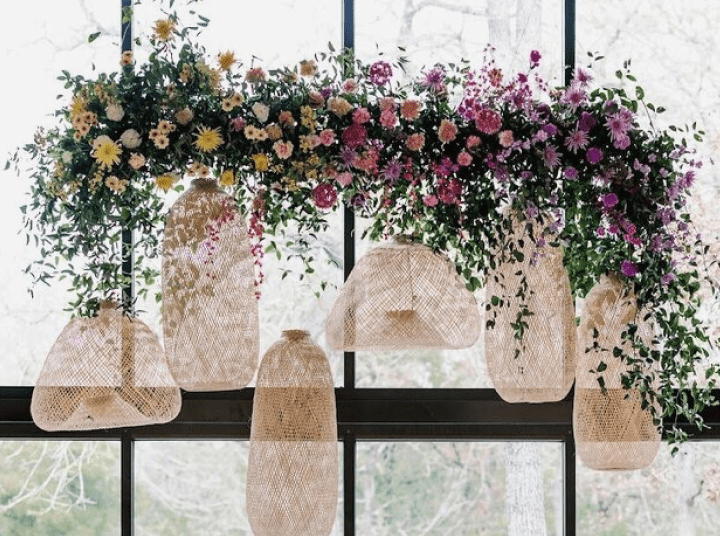 A window with flowers hanging from the ceiling.