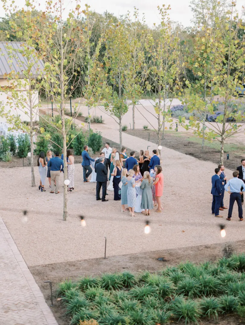 Wedding guests gather outdoors in courtyard.